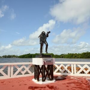 Statue of Bob Marley surrounded by vibrant scenery at Chetumal Bay, Quintana Roo, Mexico.